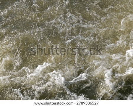 The river water flows fast, creating eddies and splashes.