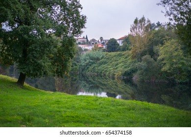 River water reflection green grass meadow tree village town landscape - Shutterstock ID 654374158