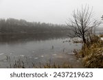 river in winter, river bank and water in winter in foggy weather