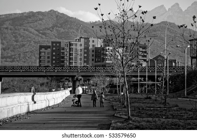 Riverbank walk. Mom with her children and a perambulator on the river Terek promenade in Vladikavkaz city, North Ossetia republic, Russia. - Shutterstock ID 533579650