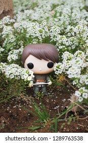 Riyadh, KSA - April 7, 2017: Game Of Thrones Character Arya Stark Portrayed Maise Williams With Her Sword By Funko Pop Vinyl Toys Surrounded By Flowers 