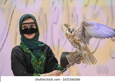 Riyadh, Saudi Arabia – October 11th 2019: Falconer Arabic woman with her falcon, used for falconry, a favorite Arab sport. Saudi Falcons and Hunting Exhibition in Riyadh Season, Saudi Arabia