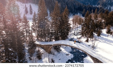 Rize Ayder Yaylası, A person on the bridge in the snowy landscape of Ayder Plateau in Rize Çamlıhemşin. View from above with a drone. Türkiye is also known as 