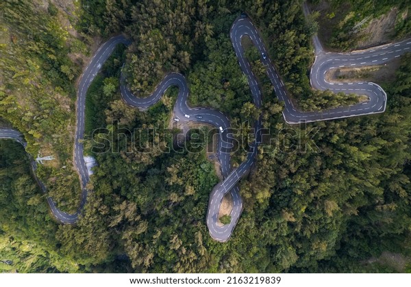 The road with 400 bends in the\
Cirque de Cilaos with aerial view by drone, Reunion\
Island