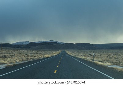 Road ahead with storm clouds above mountain in Oregon, USA