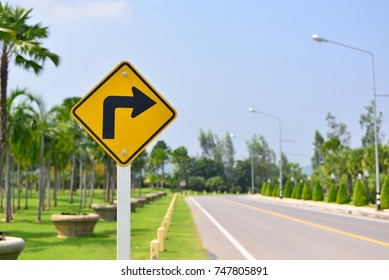 The Road Ahead Turn Right, Road Symbol Signs And Traffic Symbols For Roadway, Yellow Board With Reflection And Concrete Post