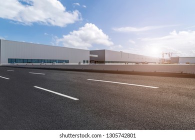 Road asphalt pavement and modern factory warehouse - Shutterstock ID 1305742801