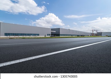 Road asphalt pavement and modern factory warehouse - Shutterstock ID 1305743005
