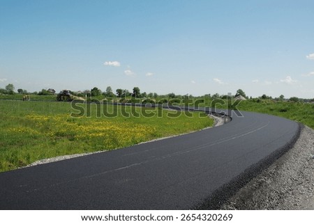 Road asphalt in progress – construction workers and machinery laying fresh asphalt on a roadway, part of infrastructure development and maintenance