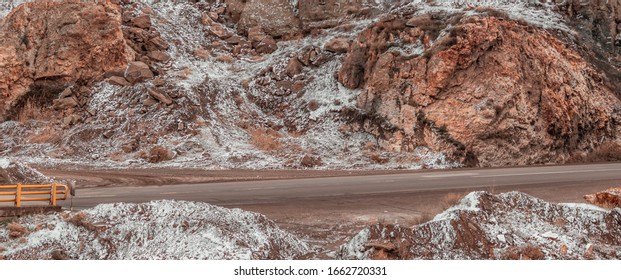 road between mountains which covered with snow in winter