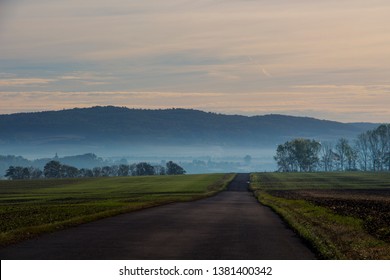 Road between two fields in the sunrise