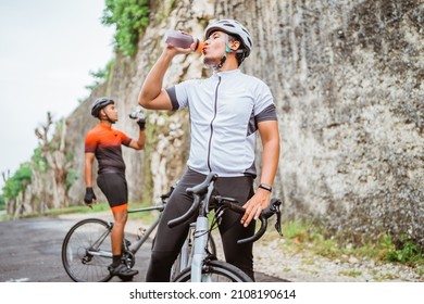 road bike cyclist take a brake and drink a bottle of water - Powered by Shutterstock