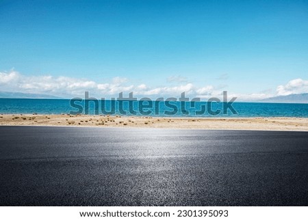 A road with a blue sky and the sea in the background