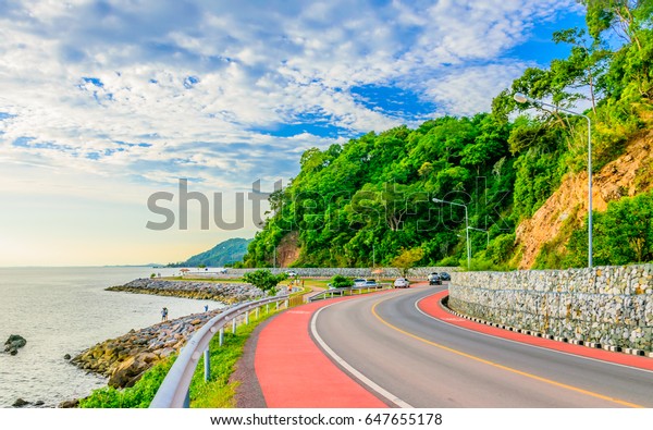 The\
road with blue sky sea and mountains on a\
background