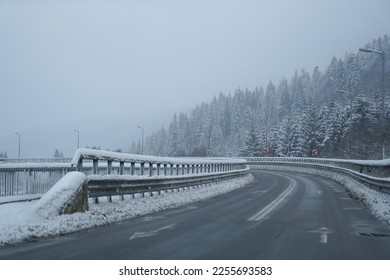 road. bridge over a valley in winter. the snow. low road traffic due to weather phenomena.