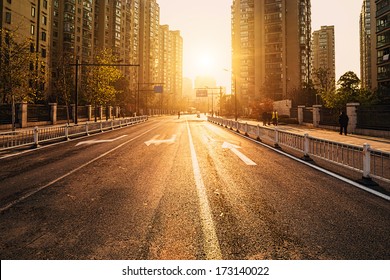 Road And Buildings At City With Sunset