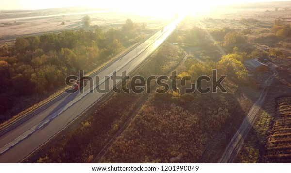 road for cars aerial view from top around green\
nature and sun ray