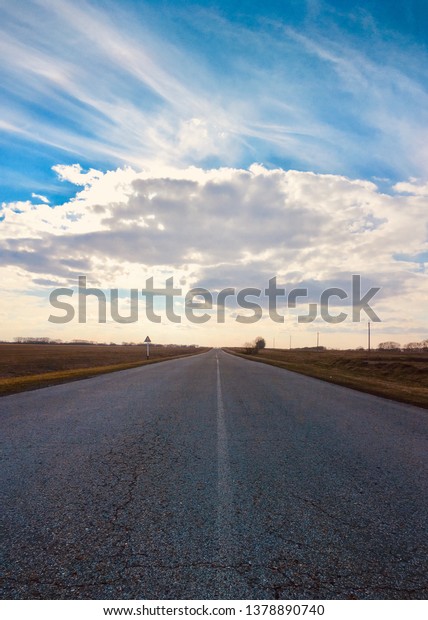 The road in the city, asphalt. Vertical photo.\
Against the blue sky