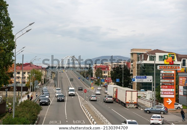 Road in the city\
with busy car traffic. Russia Sochi November 2021. Pedestrians walk\
along the sidewalk.
