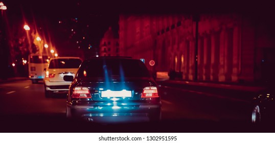 The Road In The City At The Night With Yellow And Red Electrical Light For Cars During They Are Coming Home. Rear View Of The Car At Night