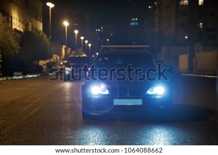 Road in the city at the night with yellow and red electrical light for cars during they are coming home. The cars compete at night. Only the lights of night carriages.