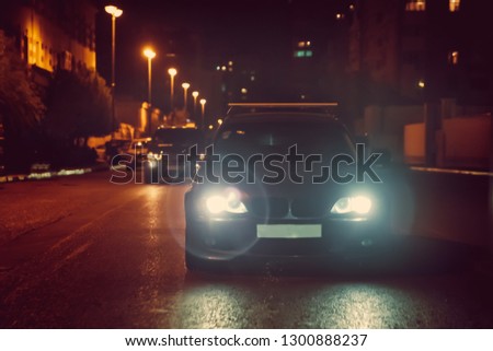 Road in the city at the night with yellow and red electrical light for cars during they are coming home. The cars compete at night. Only the lights of night carriages.