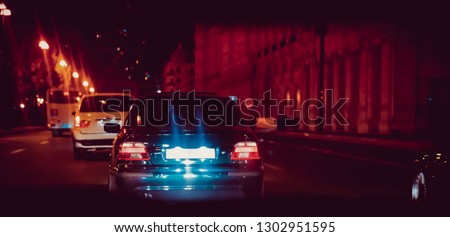 the road in the city at the night with yellow and red electrical light for cars during they are coming home. Rear view of the car at night