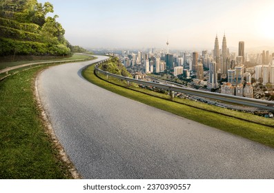 Road with cityscape and skyline in Kuala Lumpur, Malaysia. Sunrise Scene. Logo removed.