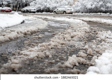 Road clening from snow and salt sprinkling . Melted snow on the road on winter season