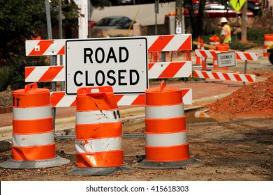 road closed sign and traffic cone in the street