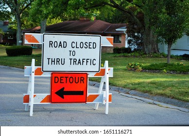 road closed to thru traffic detour construction sign in a residential neighborhood