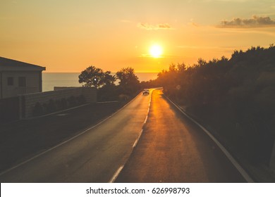 Road to the coast. Sunset at the sea. Traveling by car. Holidays, weekends in Europe