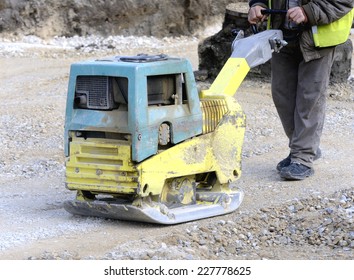 road construction worker with road leveler
