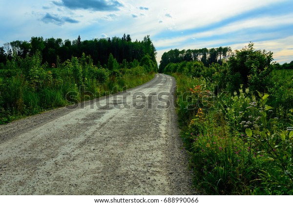 Road in the countryside,\
disappearing into the distance on the background of beautiful\
sunset