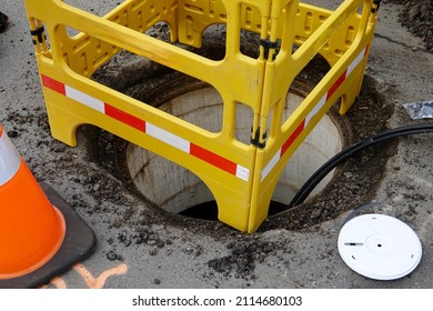 Road Crew Working Underground Installing Cable Through Manhole