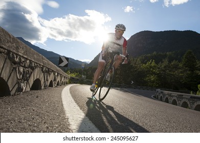 Road Cycling In The Mountains With Sunrise Behind