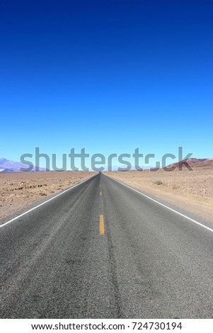Road in the Death Valley National Park with colorful sky background, California.