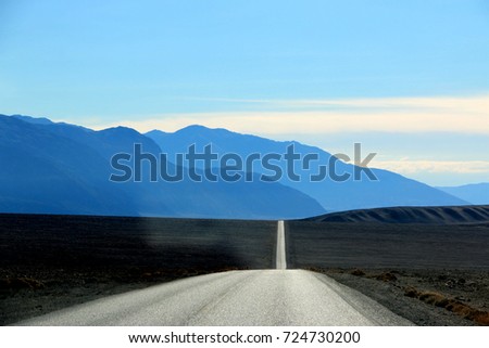 Road in the Death Valley National Park with colorful sky background, California.