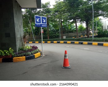 A Road With Directional Signs For Drop Off Points And Vehicle Parking Spaces