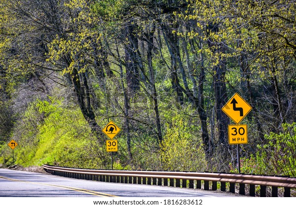 A road with a dividing lane for traffic in\
opposite directions passes through the wild forest in Colombia\
Gorge National Area and is equipped with safety fences and road\
signs for the safety driving