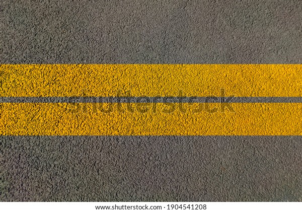 Road\
dividing yellow lines on asphalt Highway background painted for\
transport traffic control and guide vehicles for man movement\
during drive top view of Road with two\
lanes.