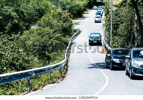 Road down hill with\
traffic, afternoon with sunny day many cars have slow down from the\
high hills
