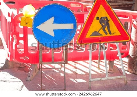 road excavation and the Caution work in progress sign and a large arrow to divert traffic