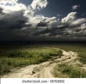 Road In Field And Stormy Clouds