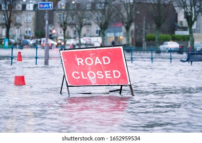 Road Flood Closed Sign Under Deep Water During Bad Extreme Heavy Rain Storm Weather In UK