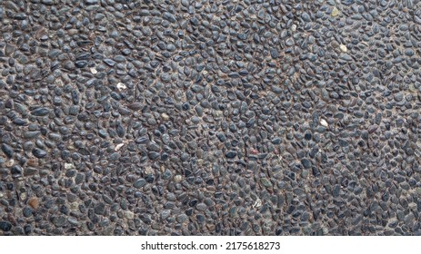 The road is formed from a collection of small stones that are neatly arranged. Cobblestone road as background.