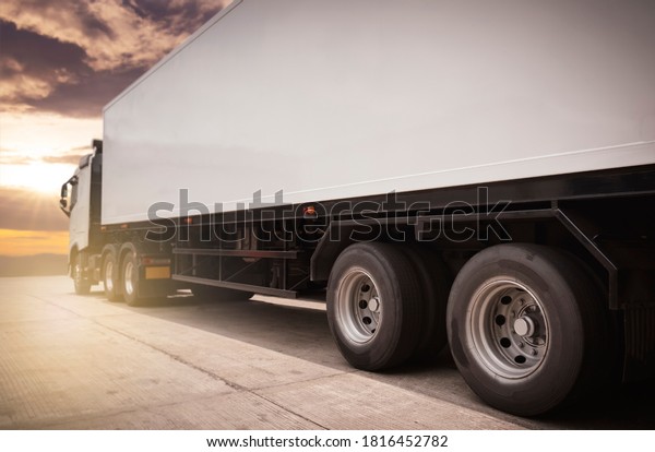 Road\
freight cargo by truck.  Shipment, Delivery service. Semi truck on\
parking at sunset sky. Logistics and\
transportation.