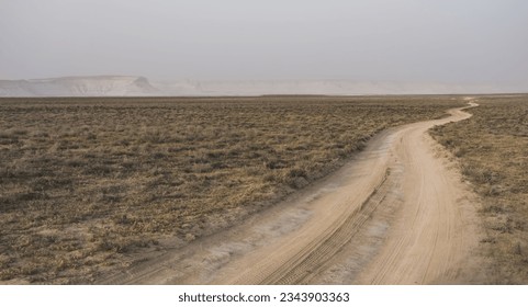 The road going into the distance in the middle of the desert steppe in Kazakhstan, the evening landscape in the desert and the highway - Powered by Shutterstock