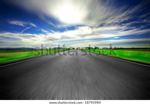 Road going straight\
ahead with motion blur