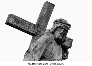The road to Golgotha. Ancient statue of Jesus Christ with cross against white background. 